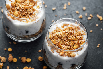 Parfaits with granola and yogurt in glass on dark  background
