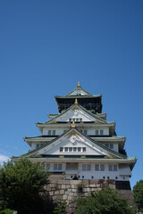 Majestic Osaka Castle standing proudly amidst lush gardens, showcasing traditional Japanese architecture and rich historical significance.