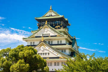 Fototapeta premium Majestic Osaka Castle standing proudly amidst lush gardens, showcasing traditional Japanese architecture and rich historical significance.