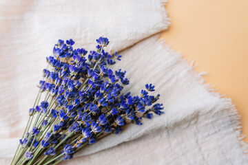 Bouquet of dried lavender on white fabric over beige background