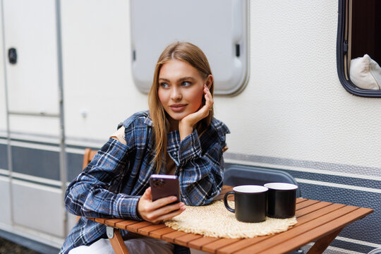 Woman driver enjoy camper parking rv area using phone app to plan next destination of travel.