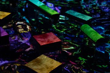 Abstract composition featuring geometric shapes and flowing metallic liquid displays arranged on a...