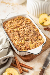 Apple pie baked oatmeal in baking dish on kitchen table background