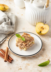 Slice of apple pie baked oatmeal in a plate on kitchen table background