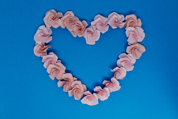 Origami is a traditional Japanese paper craft in which colored paper is folded into shapes such as flowers. This is a piece folded into the shape of a rose.