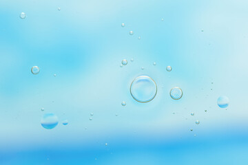 Bright abstract macro view of bubbles rising in clear light blue water. Floating clear bubbles in fresh blue fluid background