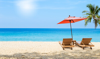 Relaxing by the sea, beach chair under red umbrella on tropical beach, summer outdoor day light