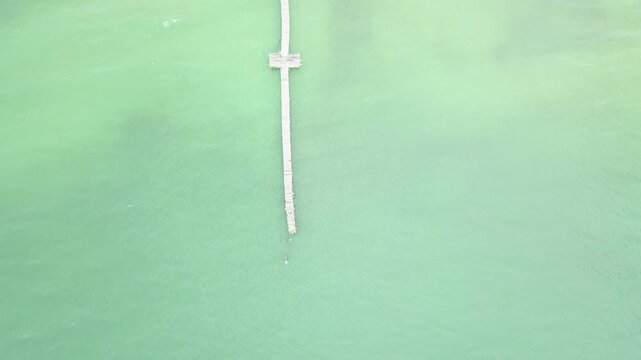 Aerial view of tranquil turquoise water with a T-shaped wooden dock