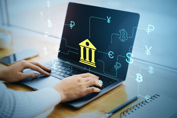 Hands typing on laptop with banking icon and digital currency symbols overlayed, representing online financial technology and secure transactions.