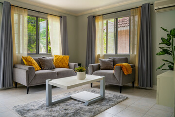 Contemporary living room space inside a model apartment with neutral decor and natural lighting