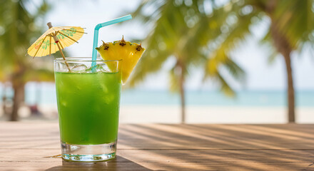 Refreshing green cocktail with pineapple garnish and a paper umbrella on a wooden table, with a beach and palm trees in the background.
