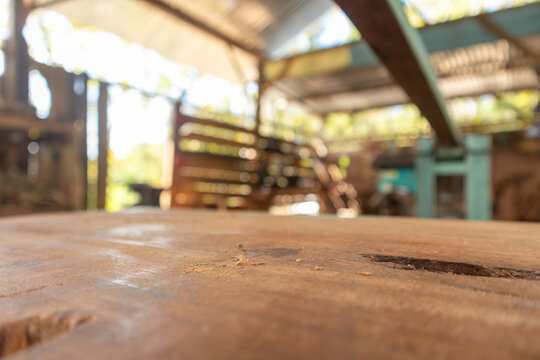 Empty wood board table for product placement or design mockup with workshop industrial background
