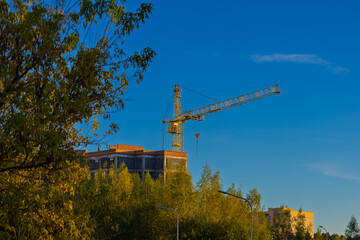 Construction of buildings and high-rise cranes against the blue sky