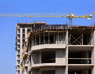 Construction of buildings and high-rise cranes against the sky
