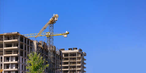 Construction of buildings and high-rise cranes against the sky