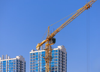 Construction of buildings and high-rise cranes against the sky