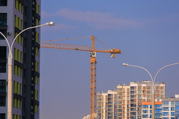 Fototapeta premium Construction of buildings and high-rise cranes against the blue sky