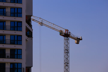 Construction of buildings and high-rise cranes against the sky