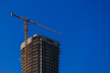 Construction of buildings and high-rise cranes against the sky