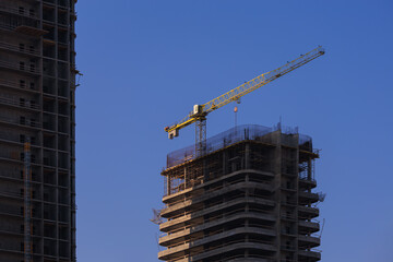 Construction of buildings and high-rise cranes against the sky