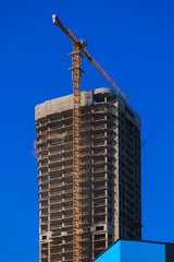 Fototapeta premium Construction of buildings and high-rise cranes against the blue sky