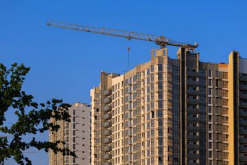 Fototapeta premium Construction of buildings and high-rise cranes against the sky