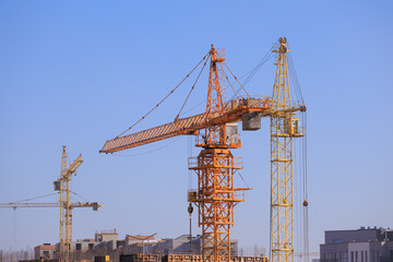 Construction of buildings and high-rise cranes against the blue sky