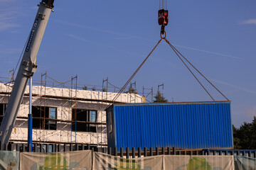 Construction of buildings and high-rise cranes against the blue sky