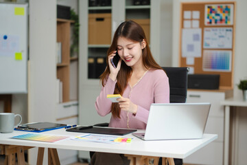 Female coder or developer working using a computer display and smartphone in problem solving at workplace.