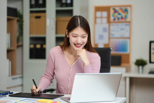 Female coder or developer working using a computer display and smartphone in problem solving at workplace.