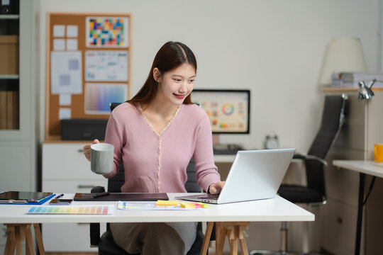 Female coder or developer working using a computer display and smartphone in problem solving at workplace.