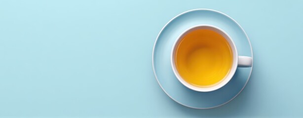 The cup of warm tea on a pastel blue background