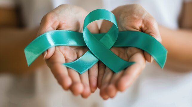 Ovarian Cancer Awareness Month. close-up of hands gently holding a teal awareness ribbon, soft natural lighting, shallow depth of field