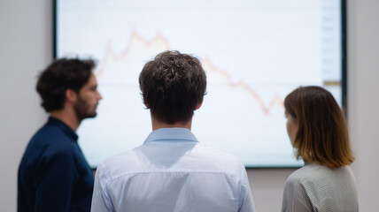 Fototapeta premium Business team analyzing economic risk and exchange rate on screen, focused and concerned in modern office