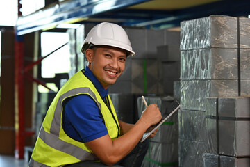 Happy warehouse employee working efficiently with tablet for stock management in an industrial storage setting