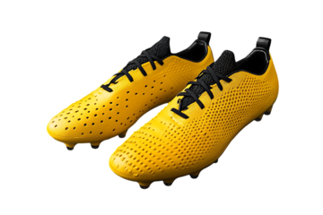 Pair of yellow soccer cleats with black laces on a black background on transparent background