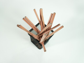Wooden pencils neatly arranged in a black wire mesh desk organizer for creative workspace