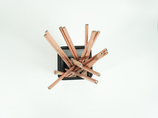 Wooden pencils in black mesh container on white background, perfect for creative work and design