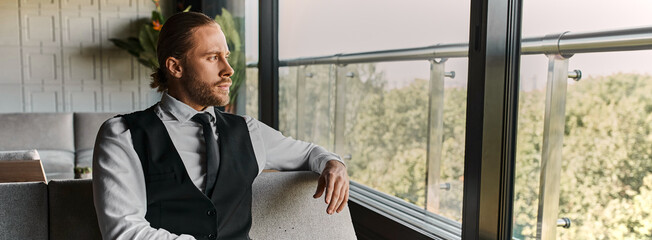 A well-dressed businessman relaxes in a stylish cafe, gazing thoughtfully out the window, banner