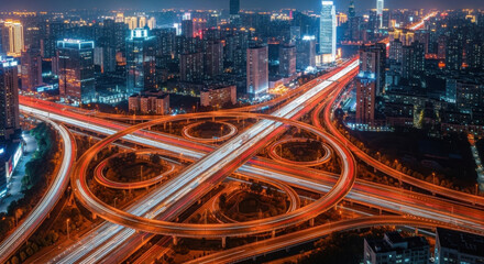 Fototapeta premium Aerial view of illuminated city highway interchange at night, vibrant urban skyline, modern architecture, dynamic traffic flow, glowing lights, energetic cityscape