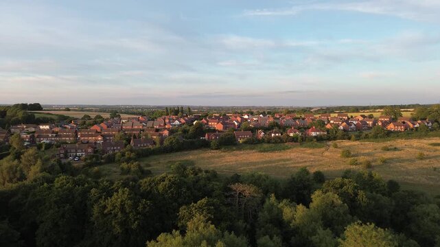 A view of a town with houses and trees. The sky is blue and the sun is shining