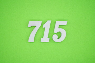The numbers are made of white painted wood and placed on a green paper background.