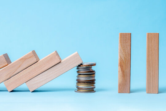 Coins Prevent Falling Dominoes From Reaching Upright Blocks, Symbolizing Financial Protection And Stability