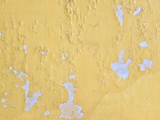 Old yellow surface wall cracked and peeling. The color on the wall fell off. 