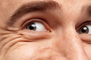 Close-up of a man expressing surprise during a sunny day outdoors at a park surrounded by trees and laughter from friends nearby