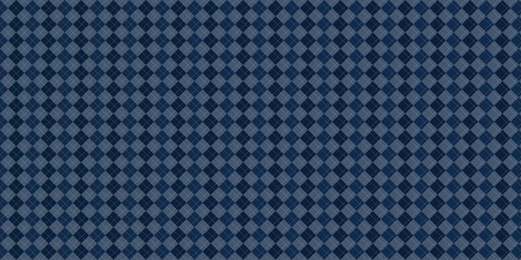Seamless pattern with a harlequin or diamond check pattern in dark blue with white dots on a blue background