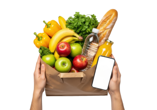 Adult hands hold an overflowing paper grocery bag with bell peppers, apples, bananas, baguette, water, and juice, next to a smartphone with a blank screen, on a white studio background with copy