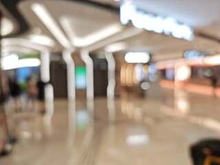 Abstract bokeh image of a shopping mall with blurred lights and people.