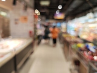 Abstract bokeh image of a bustling grocery store aisle.