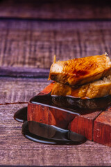 Chicken skewer tapa with soy, on wood.